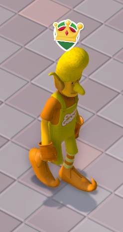 Vogelperspectief van de Cheesy Goblin, de mascotte van Cheesy Gubbins, die naar rechts wandelt. Hij draagt een oranje en geel kostuum, met oranje schoenen die als neus een krul hebben. Hij heeft puntige oren, een flinke neus, en een geel kapsel dat qua vorm een 'Gubbin' imiteert. Op de voorkant van zijn gele 'salopette' staat 'Cheesy Gubbins'. Boven zijn hoofd zweeft het 'VIP'-icoontje (een kroontje op groene achtergrond).