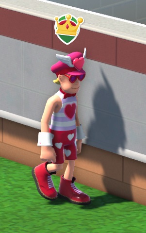 Vogelperspectief van Cupido, die naar rechts wandelt. Hij heeft blond, kort haar en draagt een fuchsia pet met een gevleugeld hartje aan de voorkant. Hij draagt een fuchsia strik, witte manchetten en een wit/indigo topje met een fuchsia hart aan de voorkant. Zijn shorts lijken eerder op een onderbroek - fuchsia, met witte hartjes erop. Boven zijn hoofd zweeft het 'VIP'-icoontje (een kroontje op groene achtergrond).