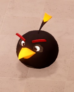 Bomb (van de 'Angry Birds'-franchise) ziet eruit als een zwarte 'bol' met een oranje bek, twee rode wenkbrauwen en een zwart/gele staart als 'lont'.