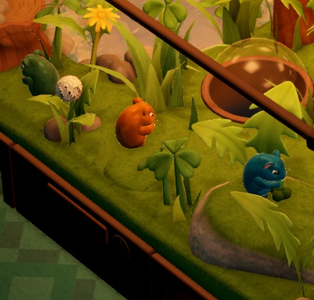 In een Terrarium zitten drie Colourwheel Hamsters - één met groene, één met geelbruine en één met donkerblauwe vacht. Rechts is een Viewing Dome te zien.