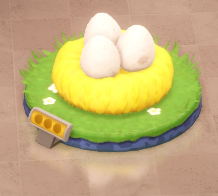 Op een cirkelvormige graszode ligt een groot nest, met daarin drie witte, grote Eieren.