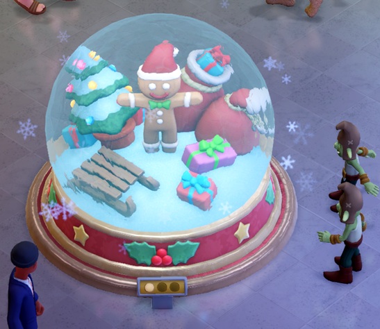 Een enorme sneeuwglobe waarin een peperkoeken mannetje zijn armen uitstrekt. Rond het mannetje liggen ingepakte cadeau's, een versierde Kerstboom en een slee. Rechts bekijken twee Goblins de Globe; linksonder passeert een gewone Bezoeker.