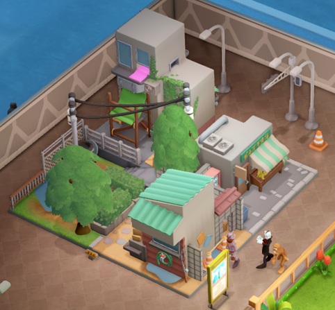 Vogelperspectief van een Little City Diorama: een 'maquette' van een stadswijk, met twee winkels (waaronder de Gecku Store), een parkje en een flatgebouw. Achter het Museumstuk staan een verkeerskegel, een verkeerslicht-paal en drie lichtposten ter decoratie. Rechtsvooraan staat een informatiebord, met drie Bezoekers: een Wetlantiër, een Yeti en een Vampier.
