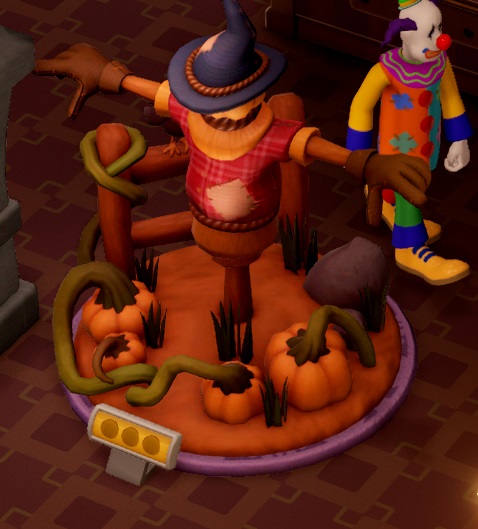 Op een cirkelvormig stukje grond ligt een pompoenplant, en een klein hekje staat aan de rand. Een enorme Vogelverschrikker met paarse heksenhoed strekt beide armen zijwaarts uit. Achter het Museumstuk loopt een Clown voorbij.