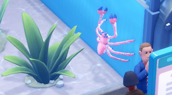 Een Spider Crab kruipt tegen een Aquariumwand omhoog, terwijl een Bezoeker rechtsonder de Infostand bekijkt.