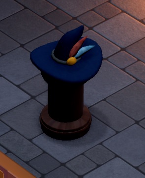 Een donkerblauwe tovenaarshoed, versierd door een rode en een lichtblauwe veer. De hoed staat op een donkere zuil.